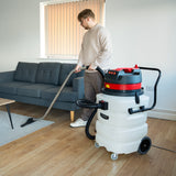 Industriesauger Maxblast 90L in Weiß mit rotem Deckel, der von einer Person in einem modernen Raum mit Holzfußboden verwendet wird