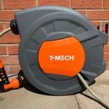 Graue Schlauchtrommel mit orangefarbenem T-MECH-Logo, ausgestattet mit einem 30m Gartenschlauch und einem schwarzen Sprühkopf, ideal für den Gartengebrauch