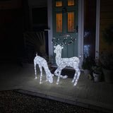 Zwei LED beleuchtete Rentiere, ein 61 cm großes Reh und ein 1,2 m hoher Hirsch, strahlen warmes Licht auf einem Gehweg vor einer Haustür aus