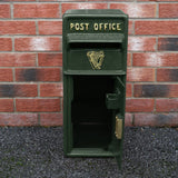 Grüner Briefkasten im irischen Stil mit goldener Schrift "POST OFFICE" und Harfenmotiv, aus robustem Material, vor einer Backsteinmauer