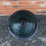 Schwarzer Kugelbrunnen mit glatter, runder Oberfläche, Wasser sprudelt sanft und erzeugt Wellen, umgeben von einer dunklen, runden Schale