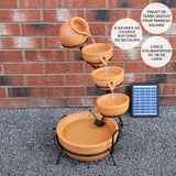 Terracotta Solar Kaskadenbrunnen mit fünf Töpfen, Wasser fließt sanft von oben nach unten, umgeben von einem stabilen schwarzen Gestell und Solarpanel