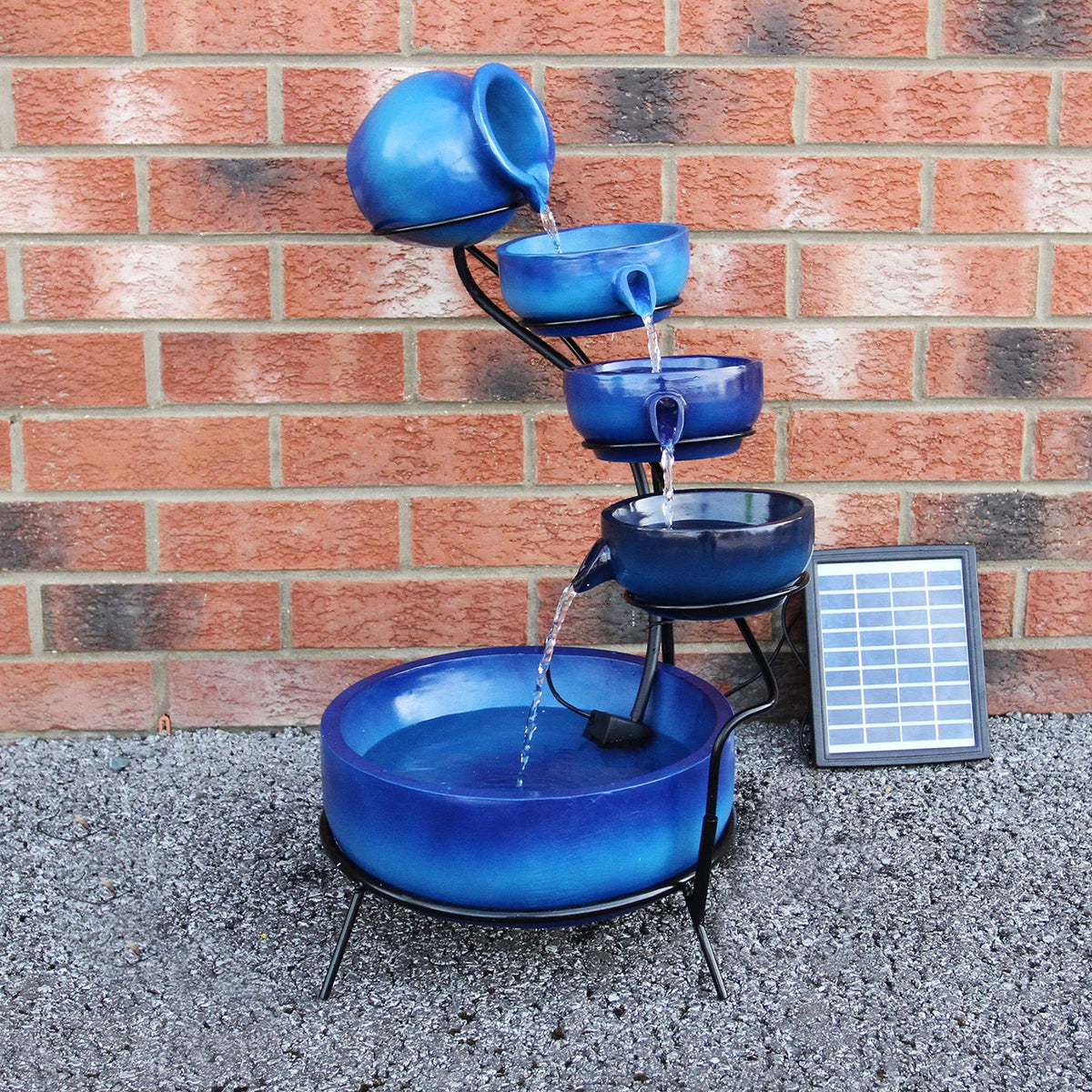 Solar Kaskadenbrunnen in Blau mit fünf Töpfen, die Wasser in eine große Schale leiten, umgeben von einem schwarzen Metallgestell und einem Solarpanel
