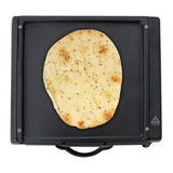 Schwarzer Mini Tandoor Ofen mit flachem, goldbraunem Naan-Brot, das auf der glatten, heißen Oberfläche liegt, ideal für indische Küche