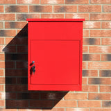 Roter Paketkasten aus Metall mit glatter Oberfläche, rechteckiger Form und einem Schloss, montiert an einer Ziegelwand