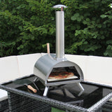 Kompakter Tisch-Pizzaofen aus Edelstahl mit einem glänzenden, silbernen Finish, der auf einem modernen Tisch steht und eine frisch gebackene Pizza zeigt