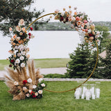 Eleganter Hochzeit Ballonbogen in Gold, geschmückt mit bunten Blumenarrangements und dekorativen Kerzen, ideal für romantische Feiern im Freien