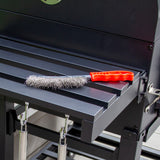 Ein schwarzer Holzkohlegrill Smoker mit einem roten Grillbürstenwerkzeug auf der Ablagefläche, ideal für das Grillen im Freien