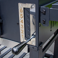 Schwarzer Grill mit glänzendem Metallzähler, der von 6 bis 1 reicht, und einem robusten Hebel für präzise Temperatureinstellungen