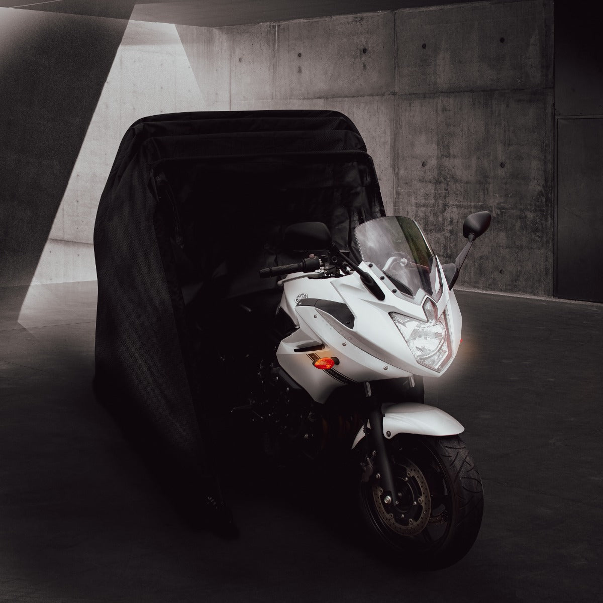 Schwarzes Motorrad Garagenzelt XXL schützt eine weiße Sportmaschine vor Witterungseinflüssen, mit glatter Oberfläche und robustem Material