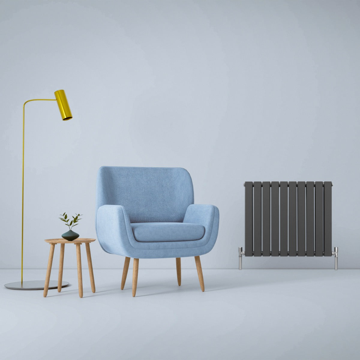 Anthrazitgrauer Paneelheizkörper mit schlanker, vertikaler Form, neben einem blauen Sessel und einem kleinen Tisch in modernem Raumdesign