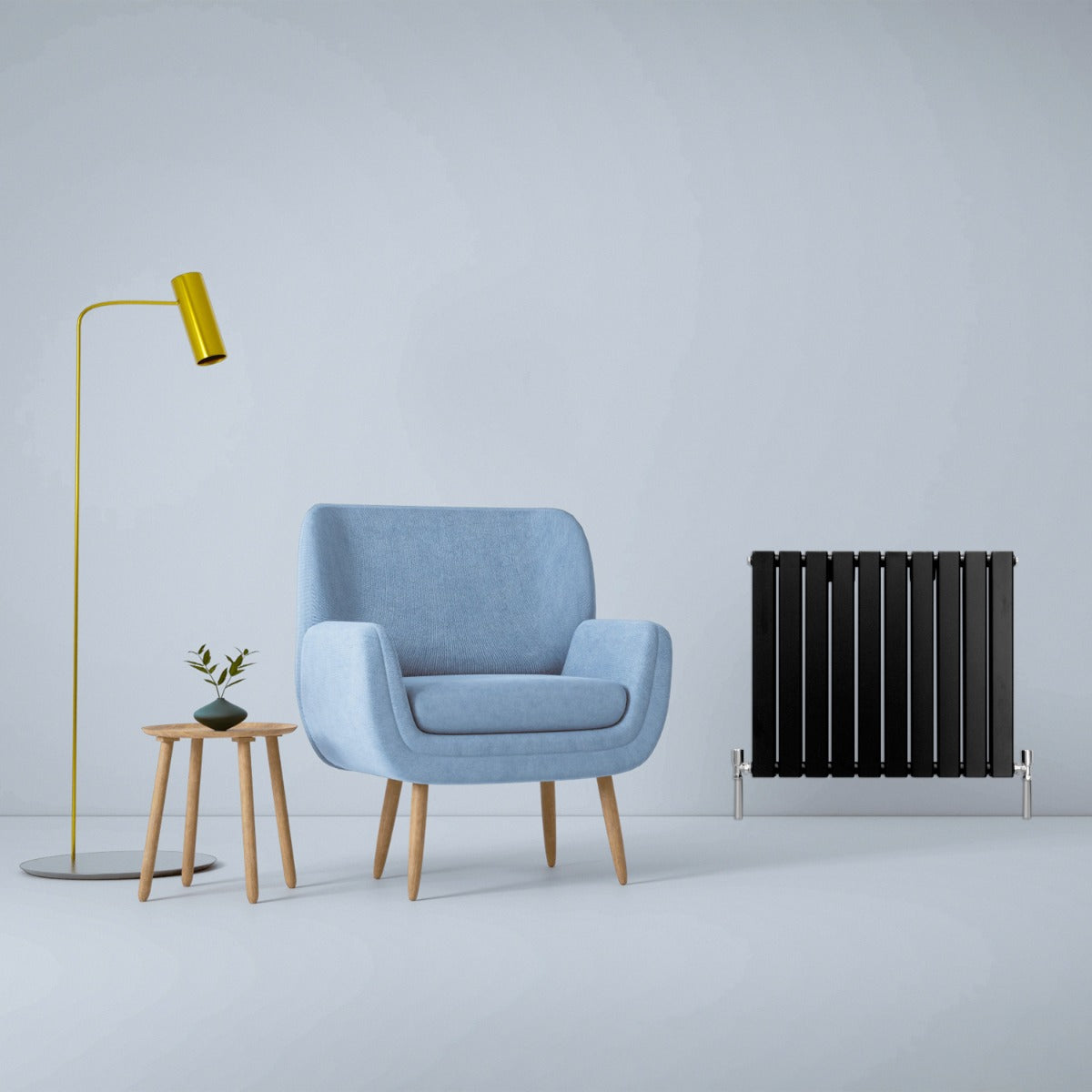 Schwarzer Paneelheizkörper mit mattem Finish, 600mm x 700mm, steht neben einem modernen blauen Sessel und einer minimalistischen Stehlampe in einem hellen Raum