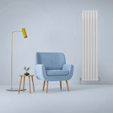 Paneelheizkörper in glänzendem Weiß, 1800mm x 420mm, steht neben einem blauen Sessel und einer modernen Stehlampe in einem minimalistischen Raum