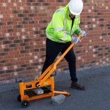 Der T-Mech 330mm Steinknacker in leuchtendem Orange wird von einem Arbeiter in Sicherheitskleidung verwendet, um einen grauen Stein zu trennen