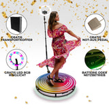 Frau in einem bunten, blühenden Kleid dreht sich auf einer 80 cm großen 360 Grad Fotokabine mit LED RGB Ringlicht und goldenen Konfetti-Elementen
