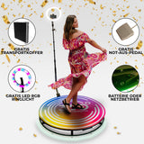 Frau in blumigem Kleid dreht sich auf einer bunten 360 Grad Fotokabine mit Ringlicht, umgeben von goldenen Konfetti-Flocken