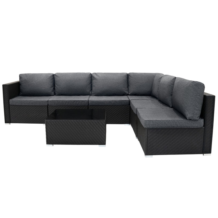 Moderne, schwarze Gartenlounge mit grauen Kissen, bestehend aus einem L-förmigen Sofa und einem passenden Glastisch, ideal für entspannte Außenbereiche
