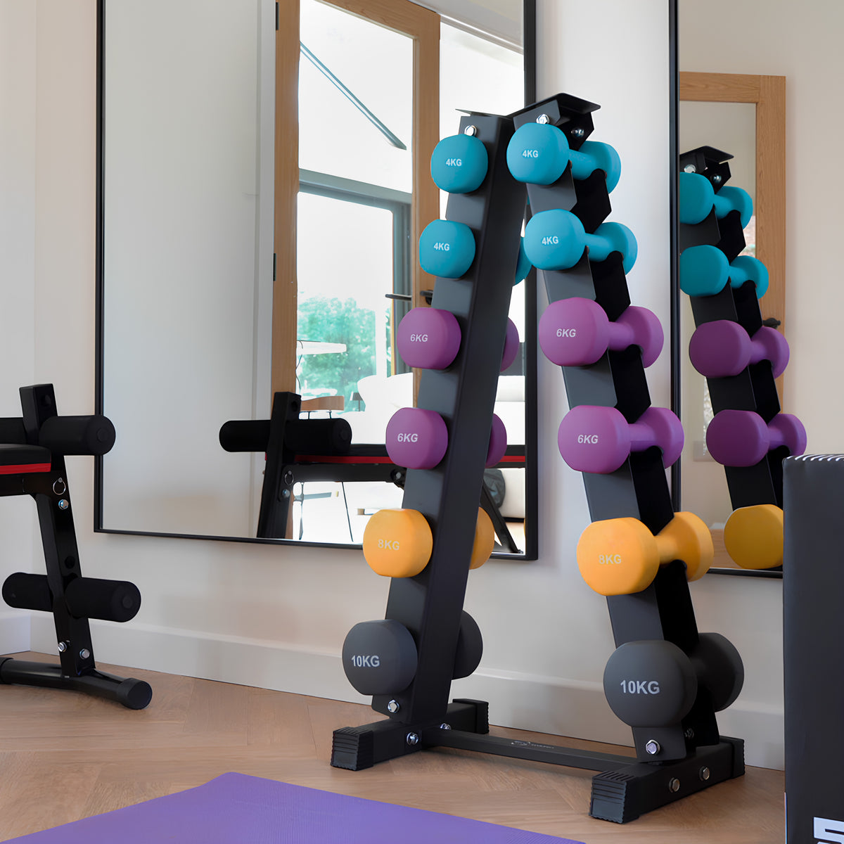 Buntes Neopren Hantel-Set mit Ständer in einem modernen Fitnessraum, zeigt Gewichte in verschiedenen Farben und Größen, reflektiert im Spiegel