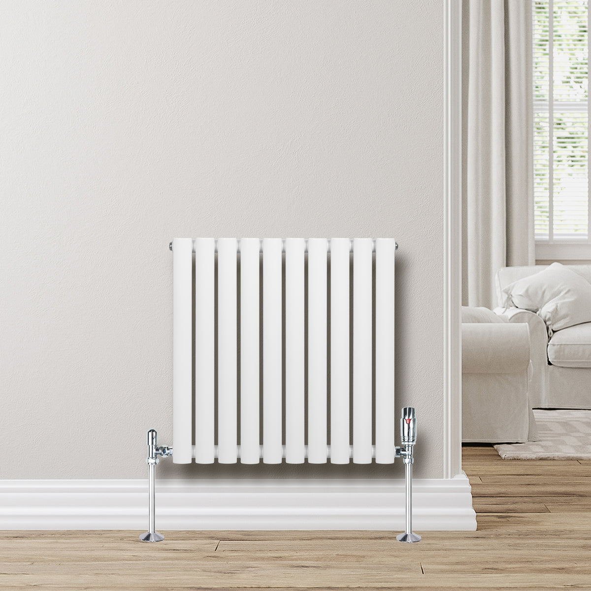 Weißer Gliederheizkörper mit TRV Chromventilen, 600mm x 600mm, an einer hellen Wand, umgeben von einem modernen Wohnraum mit Holzfußboden
