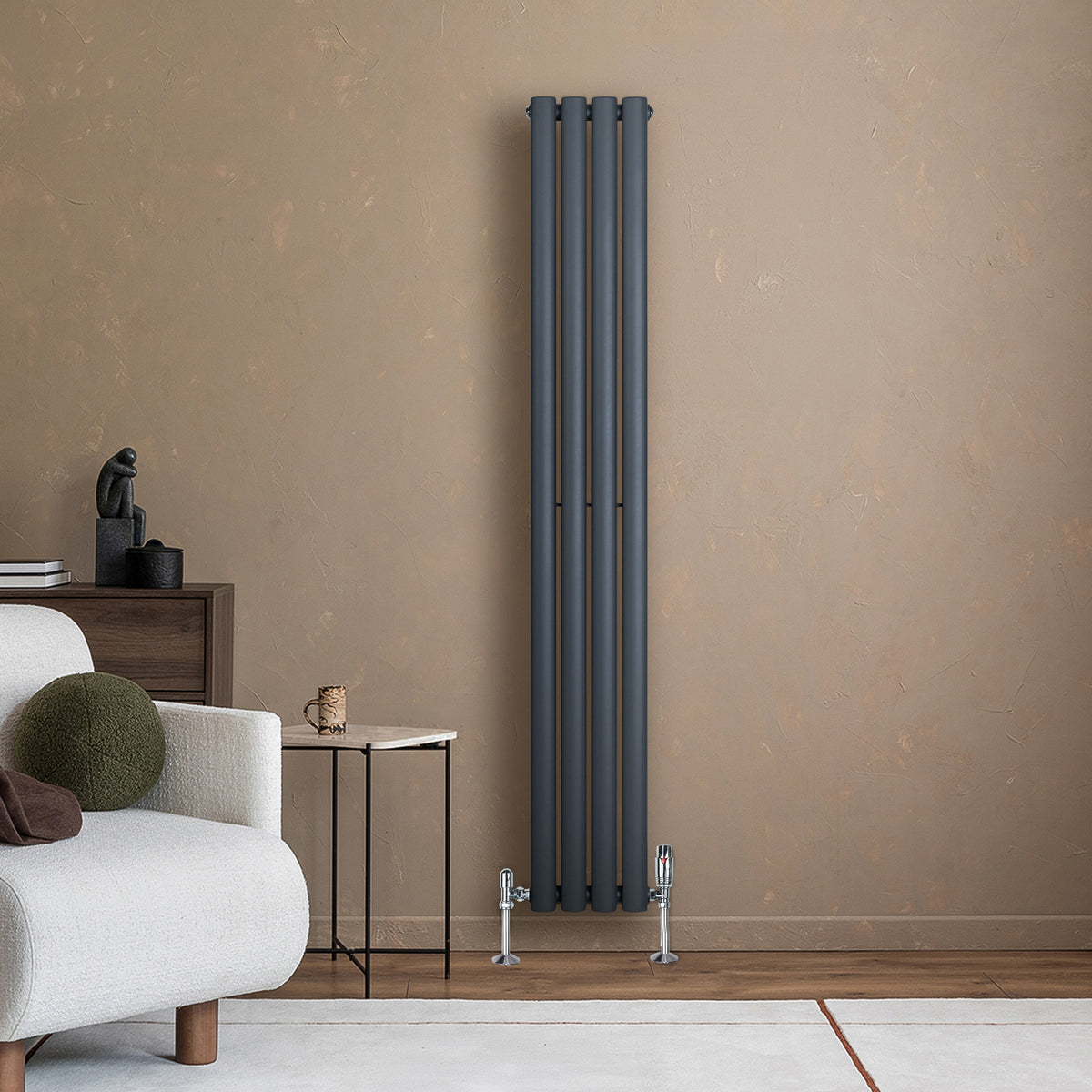 Anthrazitgrauer Gliederheizkörper mit TRV Chromventilen, 1600mm x 240mm, an einer hellen Wand, neben einem modernen Sofa und einem kleinen Tisch