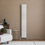Hochformatiger, weißer Gliederheizkörper mit TRV Chromventilen, elegant an einer beige Wand, umgeben von modernem Möbel und Dekor