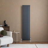 Anthrazitgrauer Gliederheizkörper mit TRV Chromventilen, 1600mm x 360mm, an einer warmen Wand, neben einem modernen Sofa und Beistelltisch