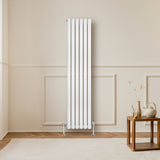 Hochformatiger, weißer Gliederheizkörper mit TRV Chromventilen, 1600mm x 360mm, vor einer hellen Wand, umgeben von einem stilvollen Holztablett und Dekoration
