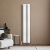 Hochformatierter, weißer Gliederheizkörper mit TRV Chromventilen, elegant an einer braunen Wand, ergänzt durch moderne Möbel und Dekoration