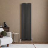 Schwarzer Gliederheizkörper mit TRV Chromventilen, 1800mm x 480mm, elegant an einer Wand, umgeben von modernem Möbel und neutralen Farben