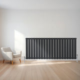 Flachheizkörper in Anthrazitgrau, 600mm x 1400mm, mit vertikalen Lamellen, elegant und modern, auf hellem Holzboden vor einer Wand platziert