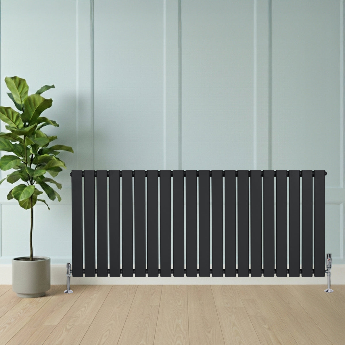 Flachheizkörper in anthrazitgrau, 600mm x 1400mm, mit vertikalen Lamellen, elegantem Design und zwei Ventilen, vor einer hellen Wand und Pflanze