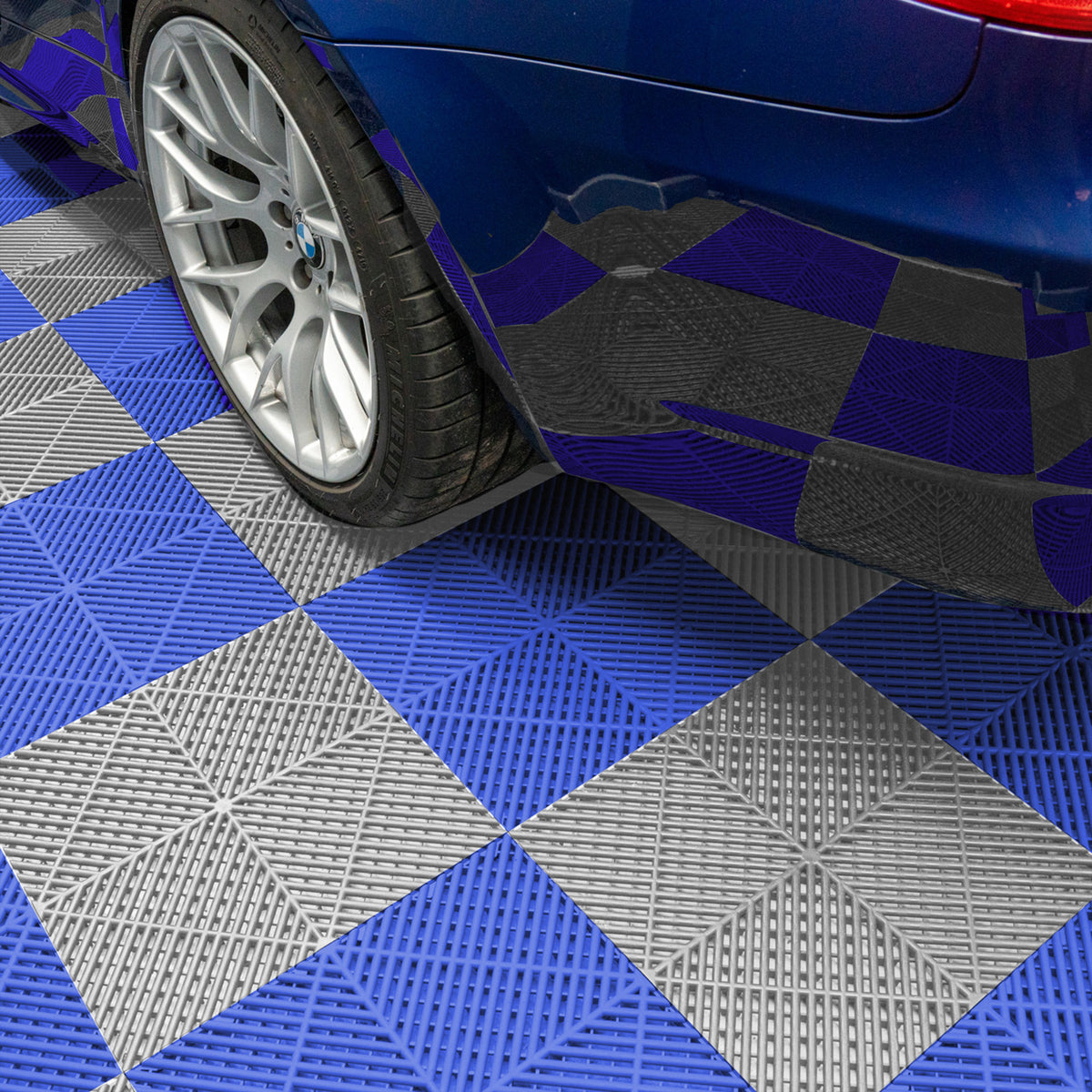 Belüftete Garagenbodenfliesen in Grau und Blau mit rutschfester Oberfläche, unter einem blauen Auto, das auf dem Muster steht