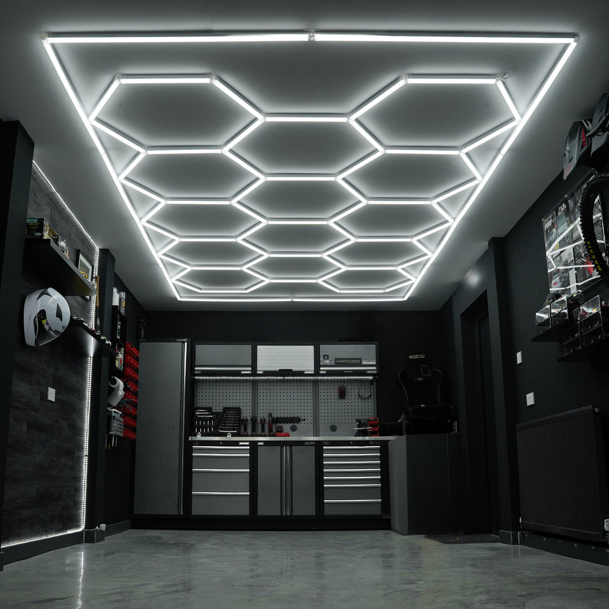 Belüftete Garagenbodenfliesen in Schwarz und Grau, kombiniert mit sechseckigen LED-Leuchten an der Decke, schaffen eine moderne, funktionale Atmosphäre