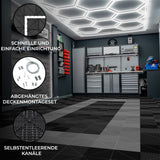 Belüftete Garagenbodenfliesen in Schwarz und Grau, sechseckige LED-Leuchten an der Decke, moderne Werkstatt mit Werkzeug und Zubehör