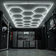 Belüftete Garagenbodenfliesen in Blau und Schwarz, kombiniert mit sechseckigen LED-Leuchten an der Decke, schaffen eine moderne, stilvolle Atmosphäre