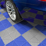 Grau und blau gestreifte Garagenbodenfliesen mit belüftetem Design, unter einem blauen Auto mit sportlichen Felgen sichtbar