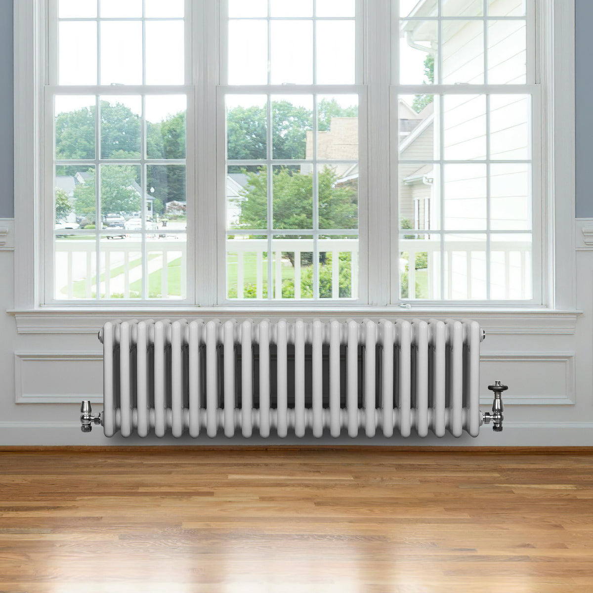 Röhrenheizkörper mit 4 Säulen in Weiß, 300mm x 1010mm, elegant und modern, platziert unter einem großen Fenster mit Holzfußboden