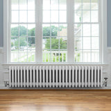 Röhrenheizkörper mit 4 Säulen in Weiß, 300mm x 1370mm, glänzende Oberfläche, elegant und modern, platziert unter einem großen Fenster in einem hellen Raum