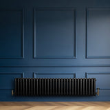 Schwarzer Röhrenheizkörper mit 4 Säulen, 300mm x 1370mm, elegant an einer blauen Wand montiert, glänzende Oberfläche und stilvolles Design
