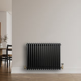 Schwarzer Röhrenheizkörper mit vier Säulen, 600mm x 785mm, glänzende Oberfläche, elegant an einer hellen Wand montiert, ideal für moderne Innenräume