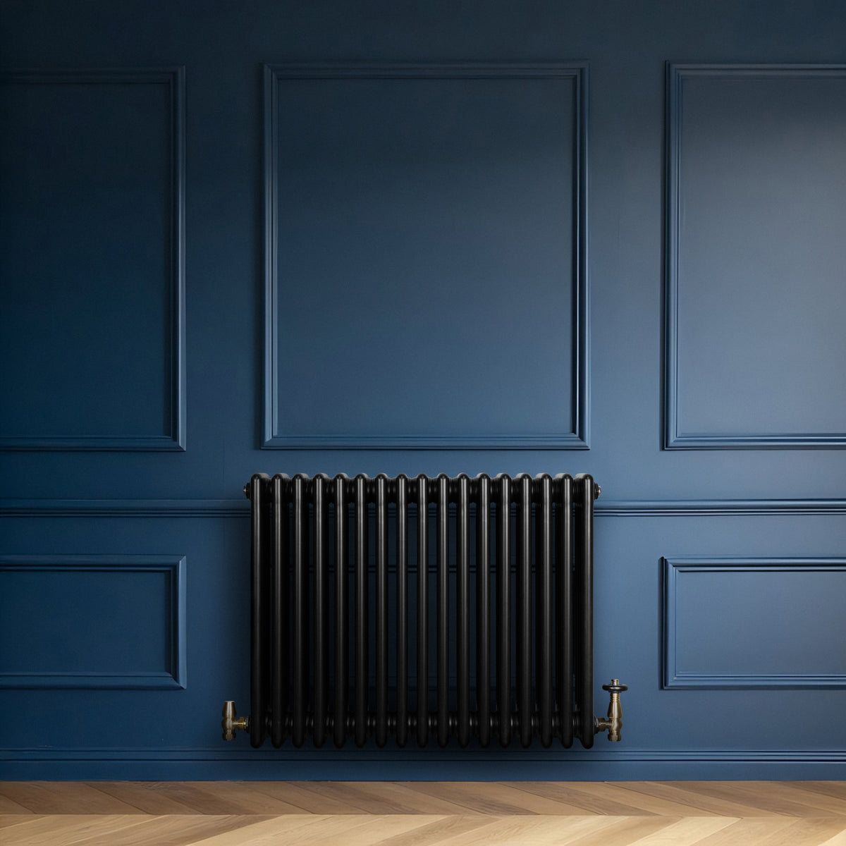 Schwarzer Röhrenheizkörper mit vier Säulen, 600mm x 785mm, vor einer blauen Wand, kombiniert mit einem eleganten Holzfußboden