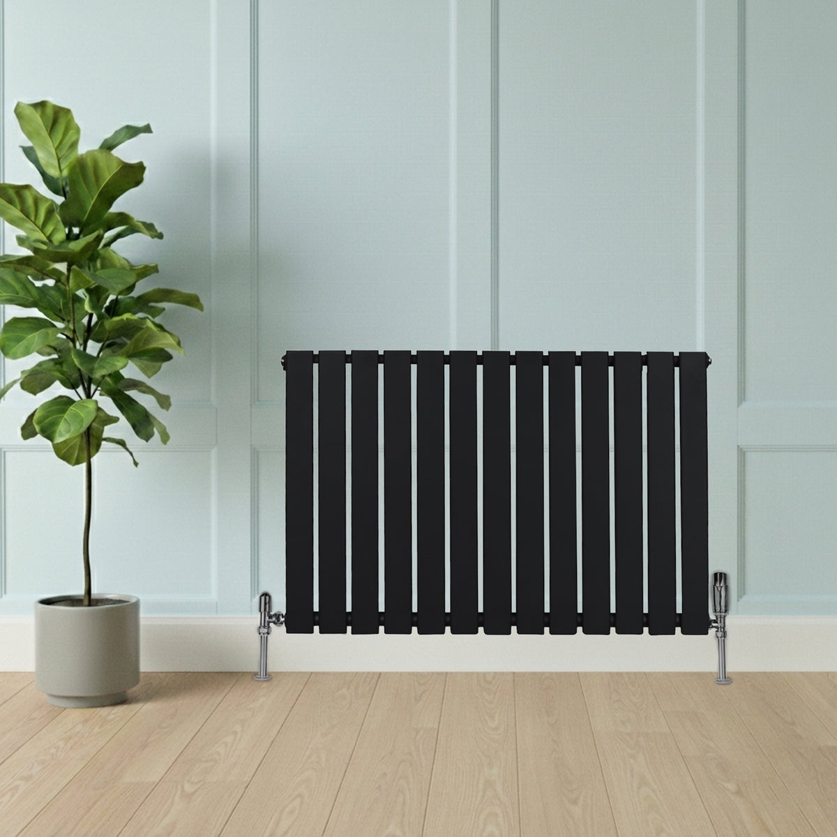 Flachheizkörper in elegantem Schwarz, 600mm x 910mm, mit schlanken, vertikalen Lamellen und modernen Ventilen, vor einer hellen Wand und Holzfußboden