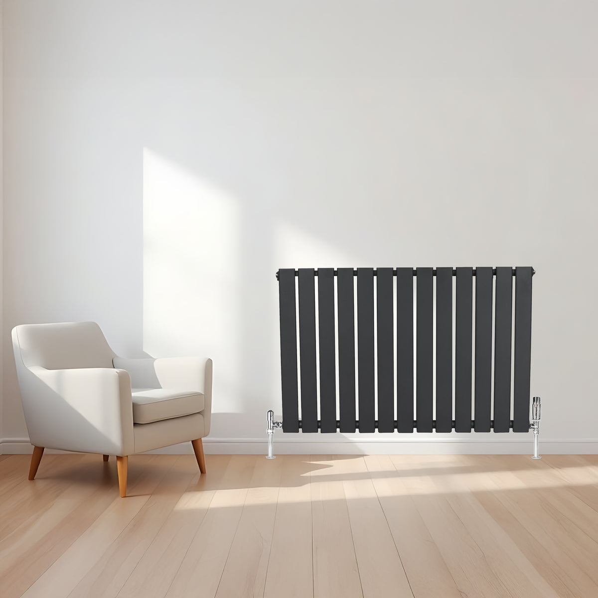 Flachheizkörper in Anthrazitgrau, 600mm x 1190mm, mit vertikalen Lamellen, elegant neben einem modernen weißen Sessel auf hellem Holzboden