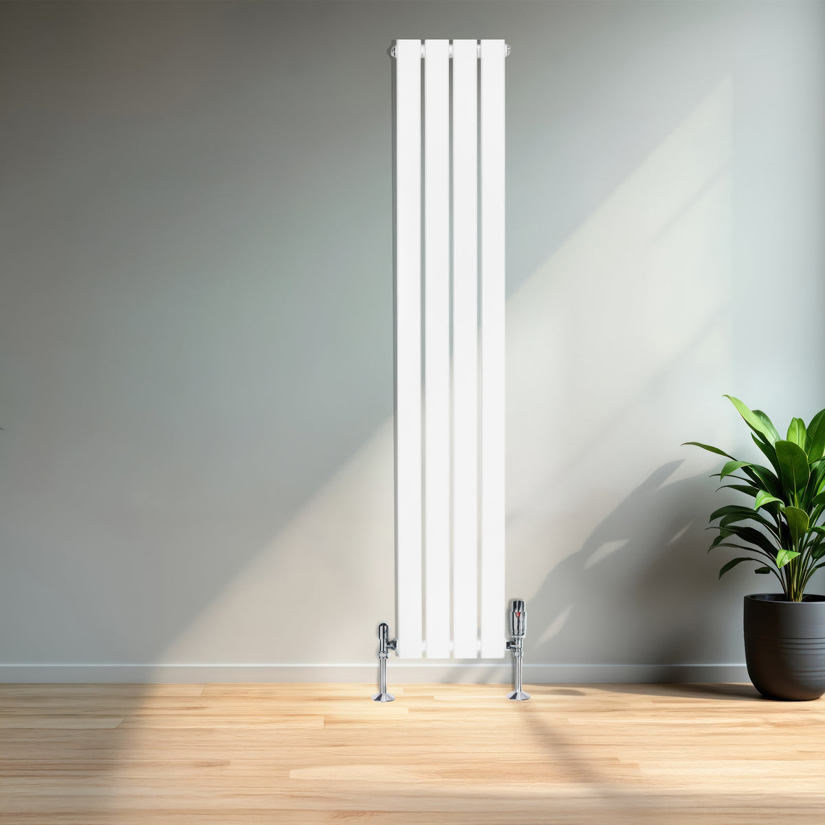 Flachheizkörper in Weiß, 1600mm x 280mm, mit glatten, vertikalen Lamellen und glänzenden, verchromten Ventilen, vor einer hellen Wand und Pflanzen im Hintergrund