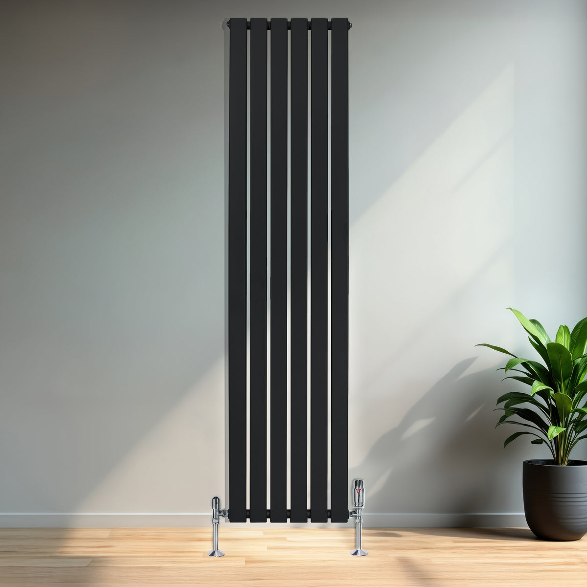 Schwarzer Flachheizkörper mit vertikalen Lamellen, 1800mm x 420mm, elegant an einer hellen Wand montiert, ergänzt durch einen modernen Raum mit Pflanzen