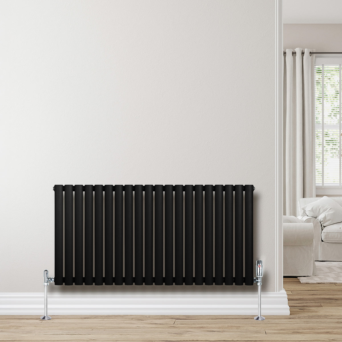 Schwarzer Gliederheizkörper mit 600mm x 1200mm, vertikalen Lamellen und glänzenden Füßen, elegant vor einer hellen Wand platziert