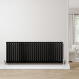 Schwarzer Gliederheizkörper mit 600mm Höhe und 1620mm Breite, elegant an einer hellen Wand montiert, ergänzt durch glänzende Fußventile