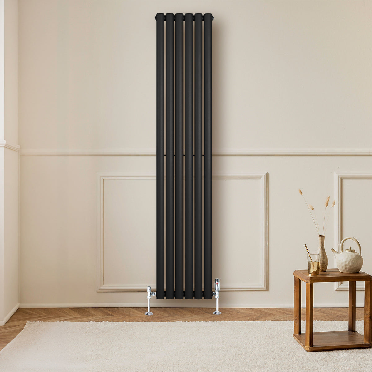 Schwarzer Gliederheizkörper mit fünf vertikalen Elementen, 1800mm hoch und 360mm breit, elegant an einer hellen Wand montiert, ergänzt durch einen Holzbeistelltisch