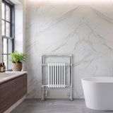 Klassischer beheizter Handtuchheizkörper in Weiß, 950 mm x 660 mm, mit glänzenden Chromdetails vor elegantem Marmorhintergrund