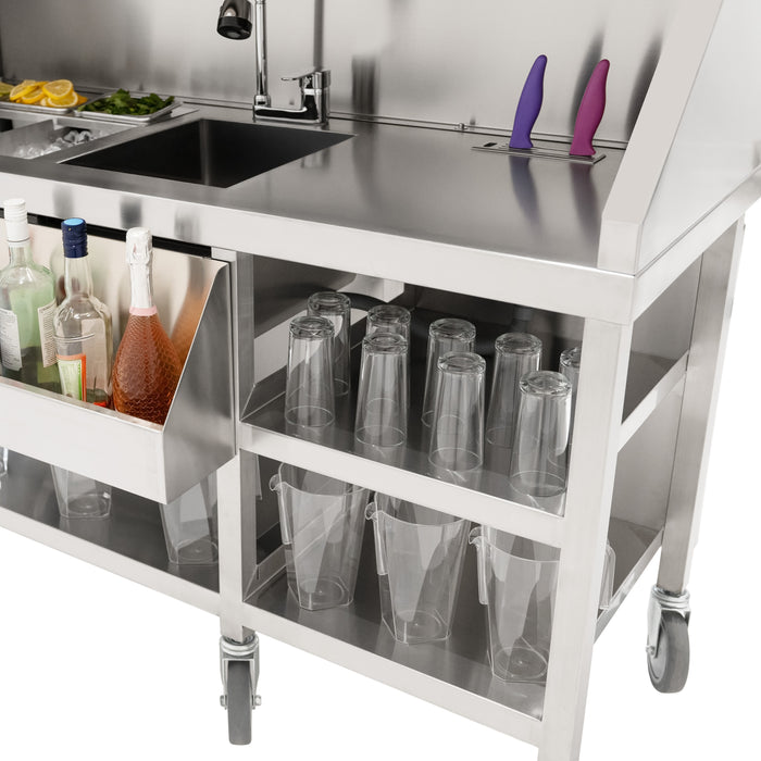 Edelstahl-Barwagen mit einem großen Waschbecken, Gläsern und Flaschen, ergänzt durch lila und rosa Küchenmesser, ideal für die Gastronomie